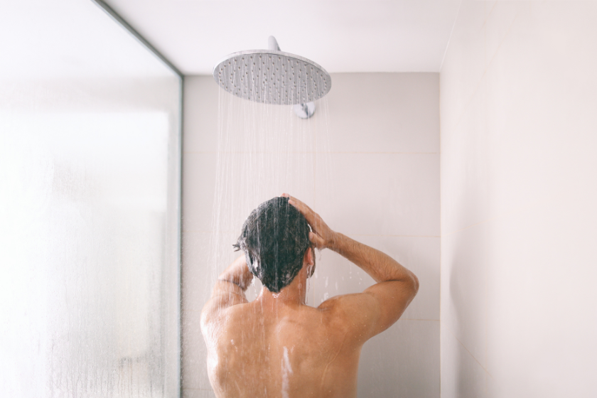 A man in the shower washing his hair