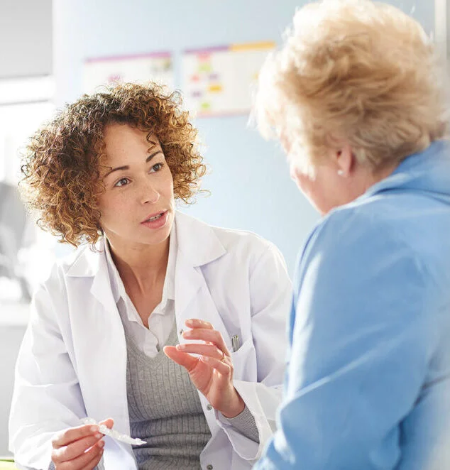 A female doctor carefully explaining something to an older, female patient.